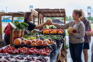A woman buying fresh produce at the frisco fresh farmers market